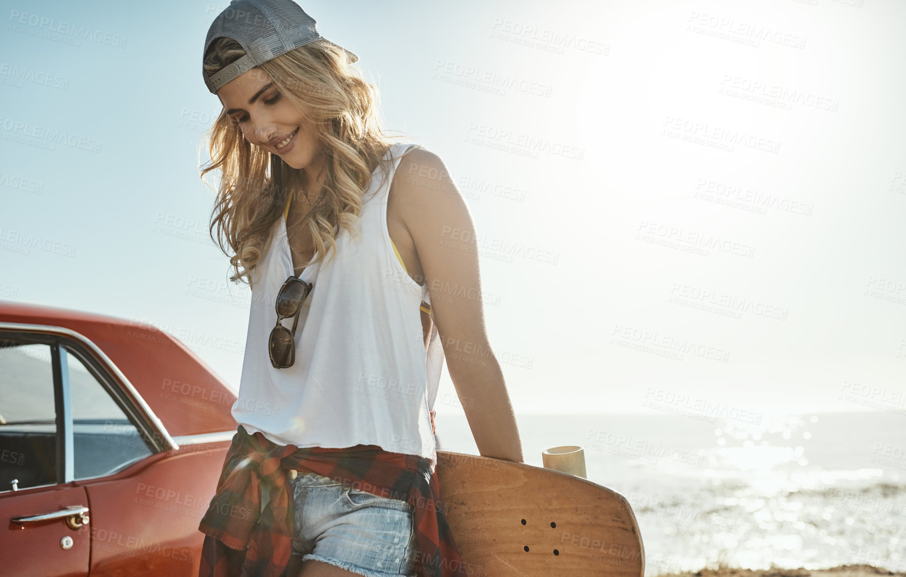 Buy stock photo Cropped shot of an attractive young woman holding a skateboard while on a road trip