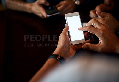 Buy stock photo Closeup of an unrecognizable man texting on his phone while being seated inside of a bar at night