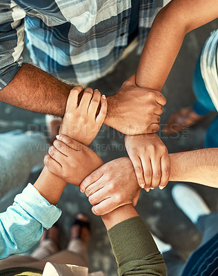 Buy stock photo High angle shot of a young group of work colleagues forming an unique huddle with their arms and hands while standing in the office at work