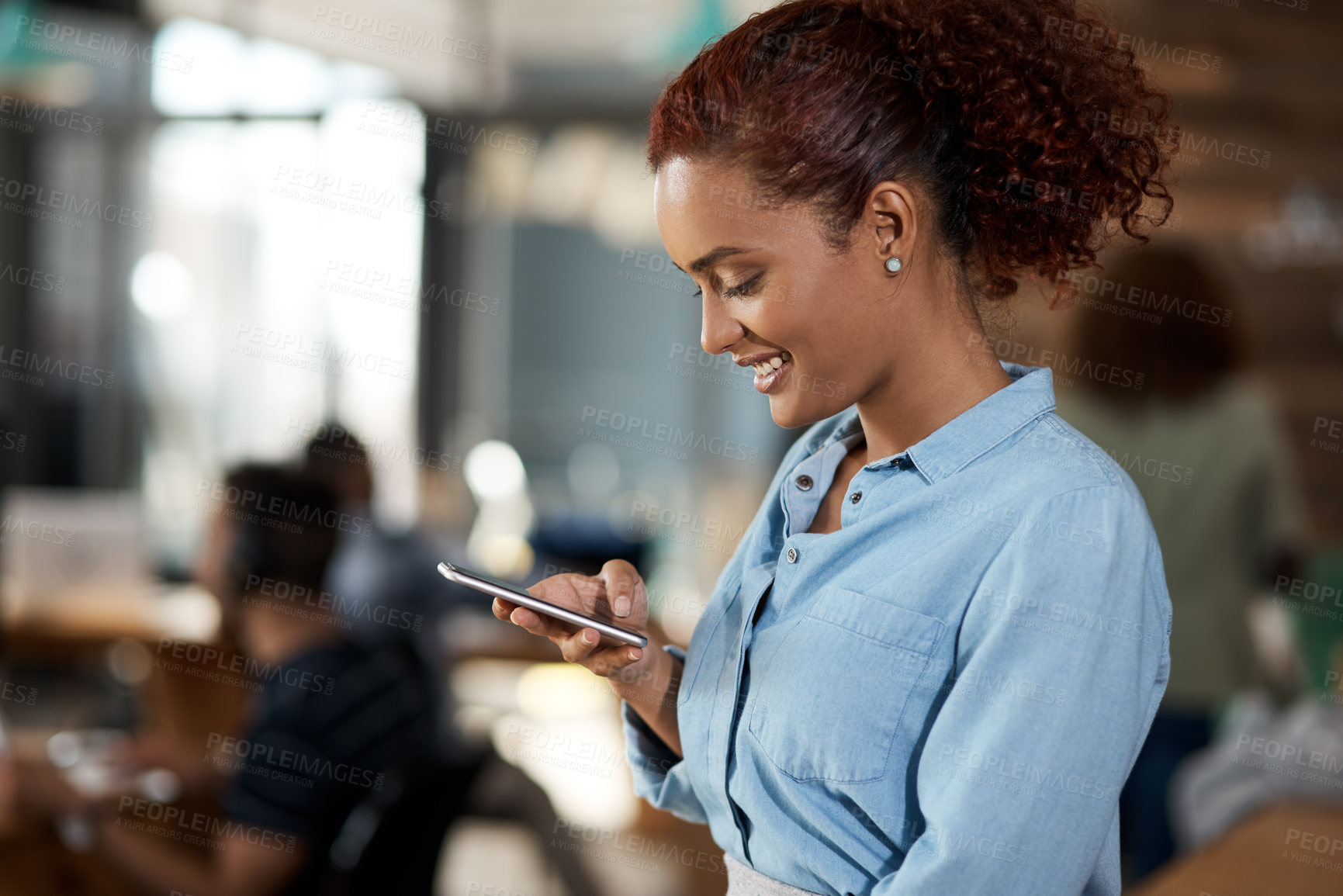 Buy stock photo Shot of an attractive young businesswoman using a cellphone in an office