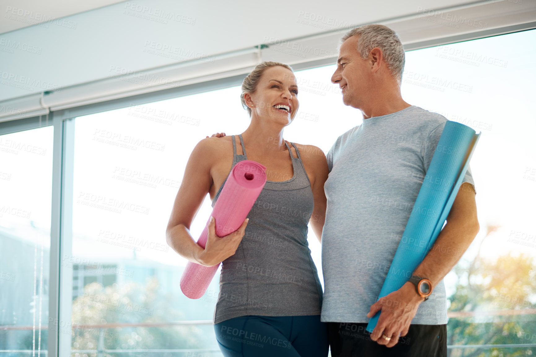 Buy stock photo Cropped shot of an affectionate mature couple standing with their yoga mats at home