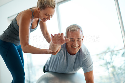 Buy stock photo Cropped shot of an attractive mature woman helping her husband with his workout at home