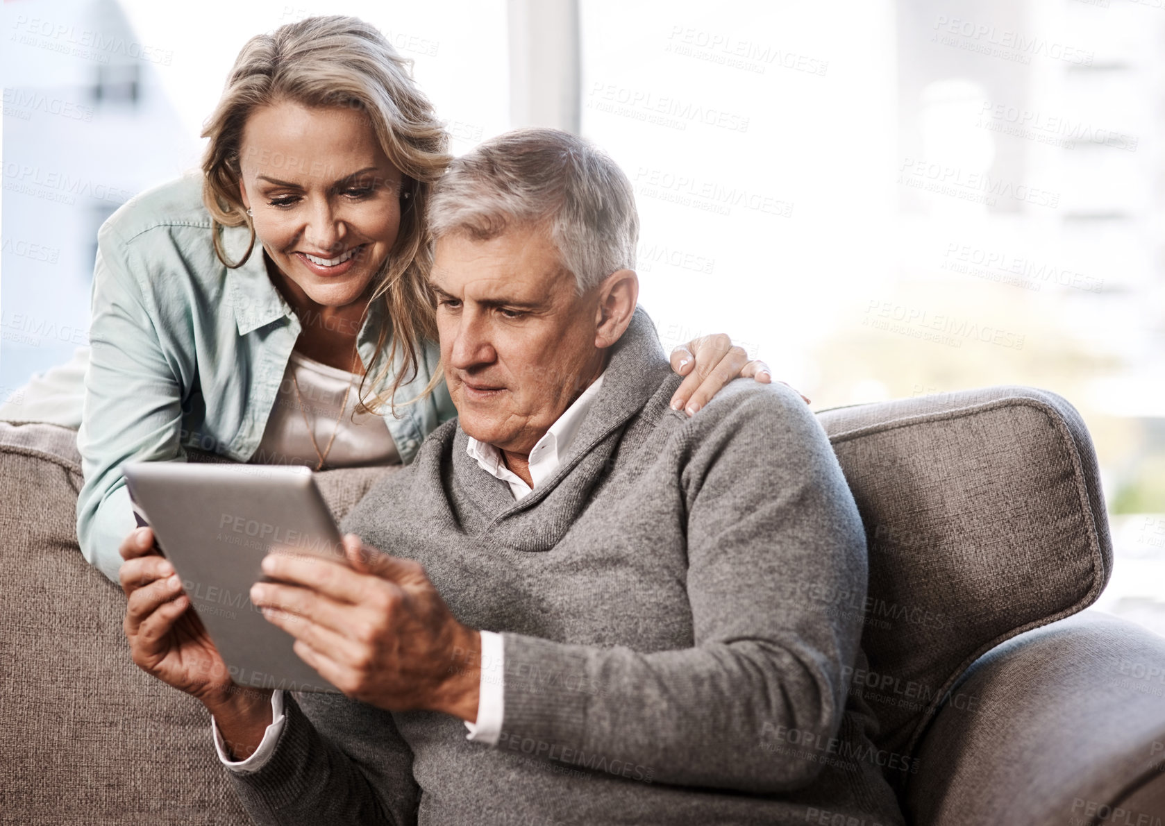 Buy stock photo Shot of a mature couple using a digital tablet and credit card to do online shopping at home