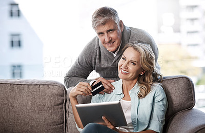Buy stock photo Portrait of a mature couple using a digital tablet and credit card to do online shopping at home