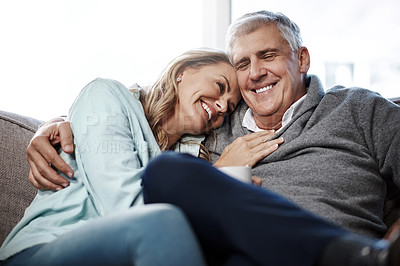 Buy stock photo Shot of a mature couple relaxing on the sofa together at home