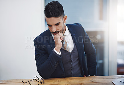 Buy stock photo Shot of a young businessman looking thoughtful in an office