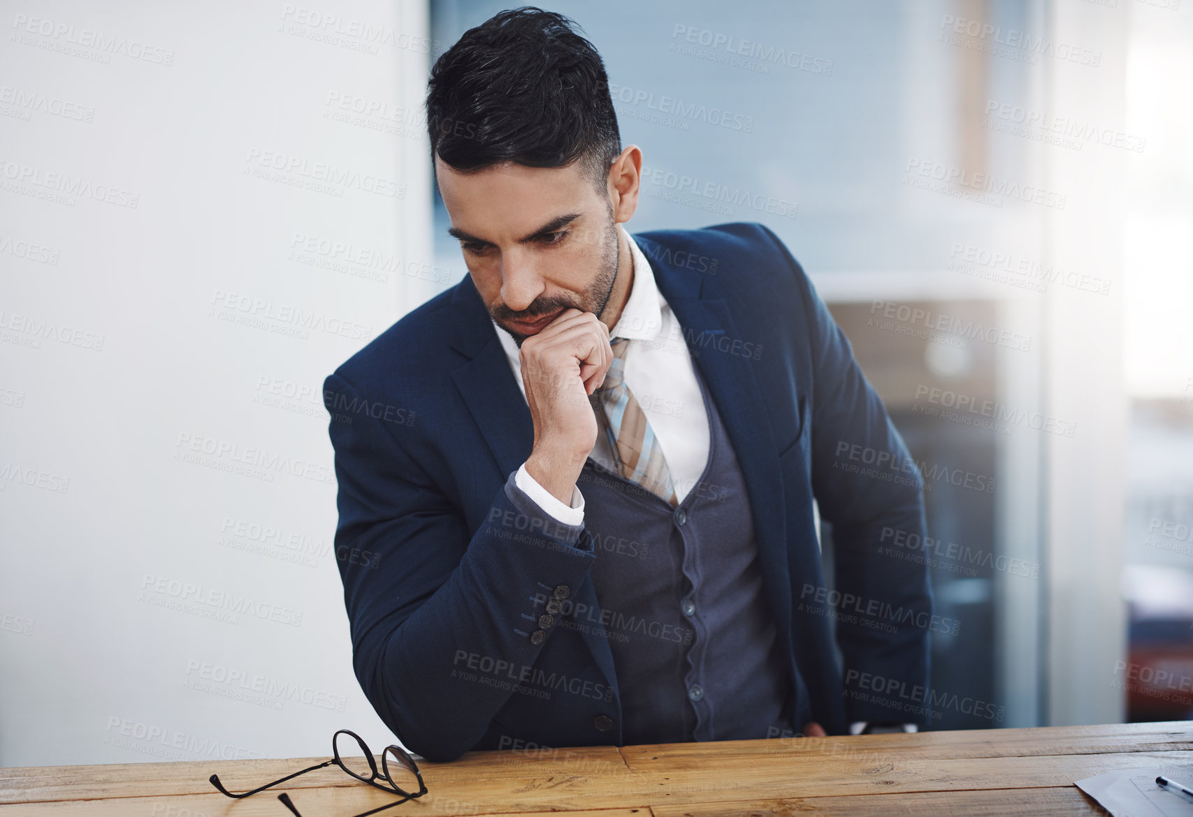 Buy stock photo Shot of a young businessman looking thoughtful in an office