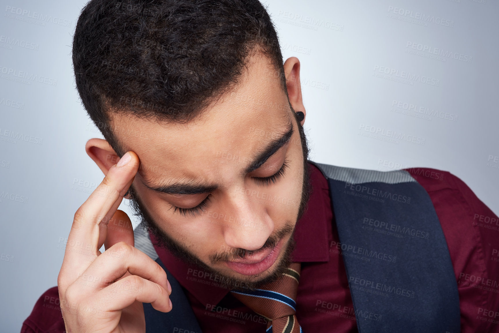 Buy stock photo Studio shot of a handsome young businessman experiencing a headache against a grey background