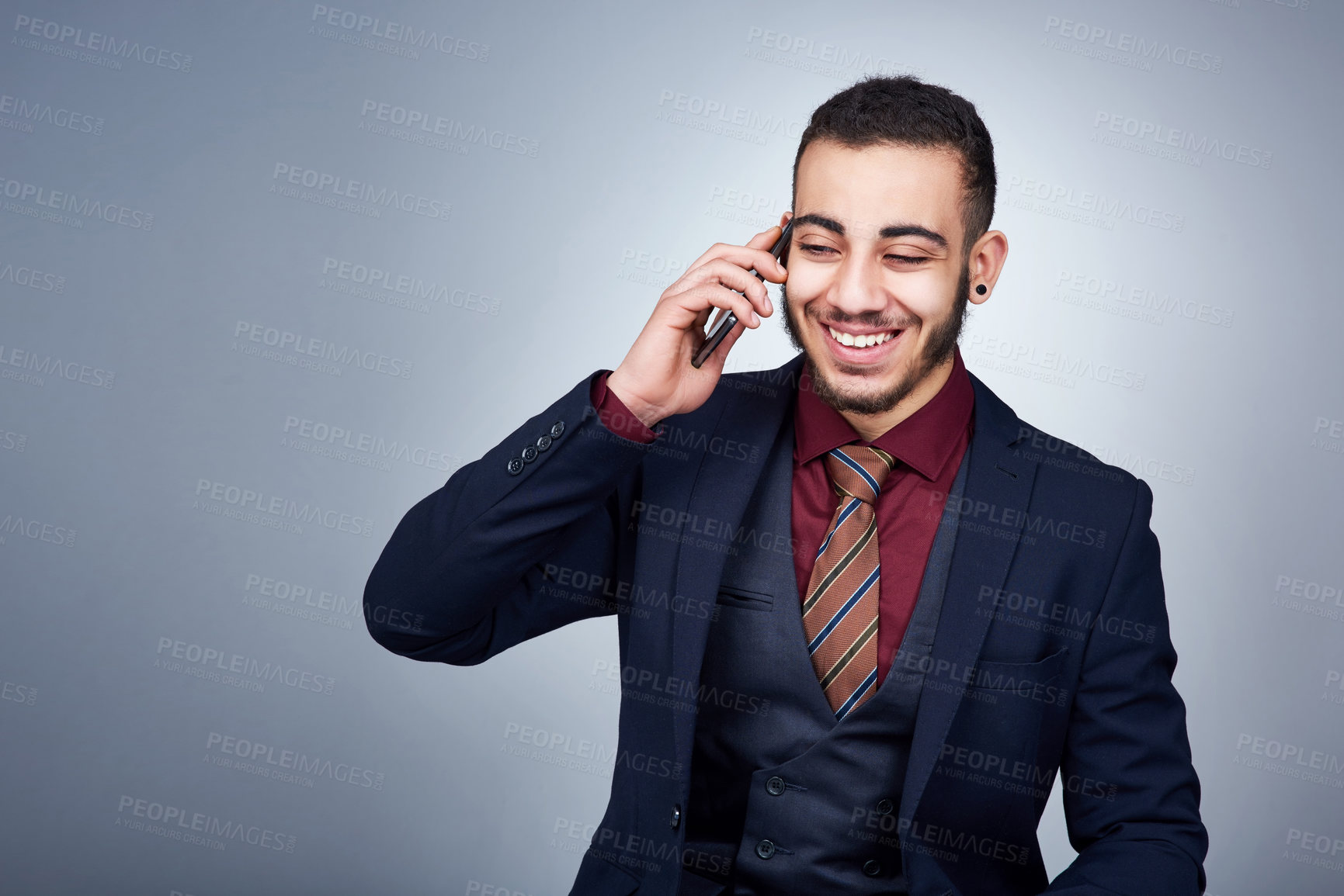 Buy stock photo Studio shot of a handsome young businessman on a call against a grey background