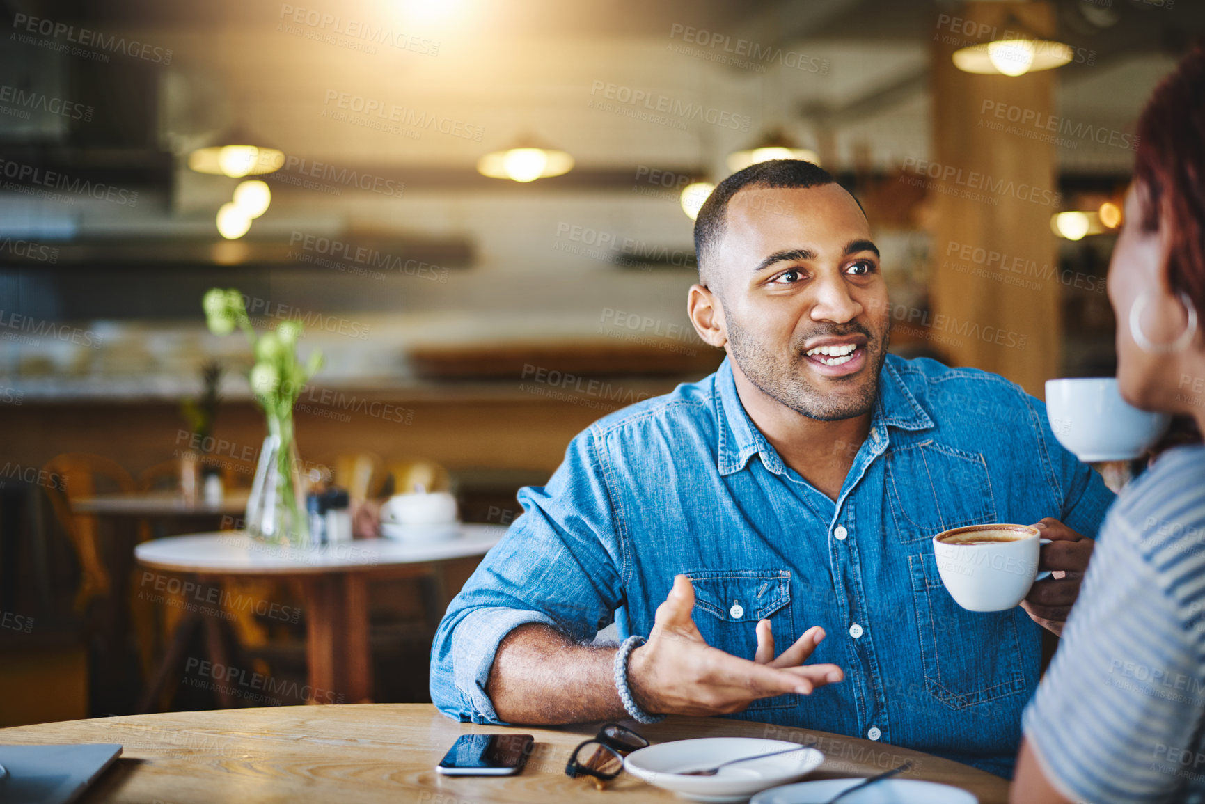 Buy stock photo Cropped shot of a handsome young man spending time with his girlfriend in a coffee shop