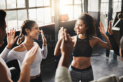 Buy stock photo Shot of a group of young people working out together in a gym