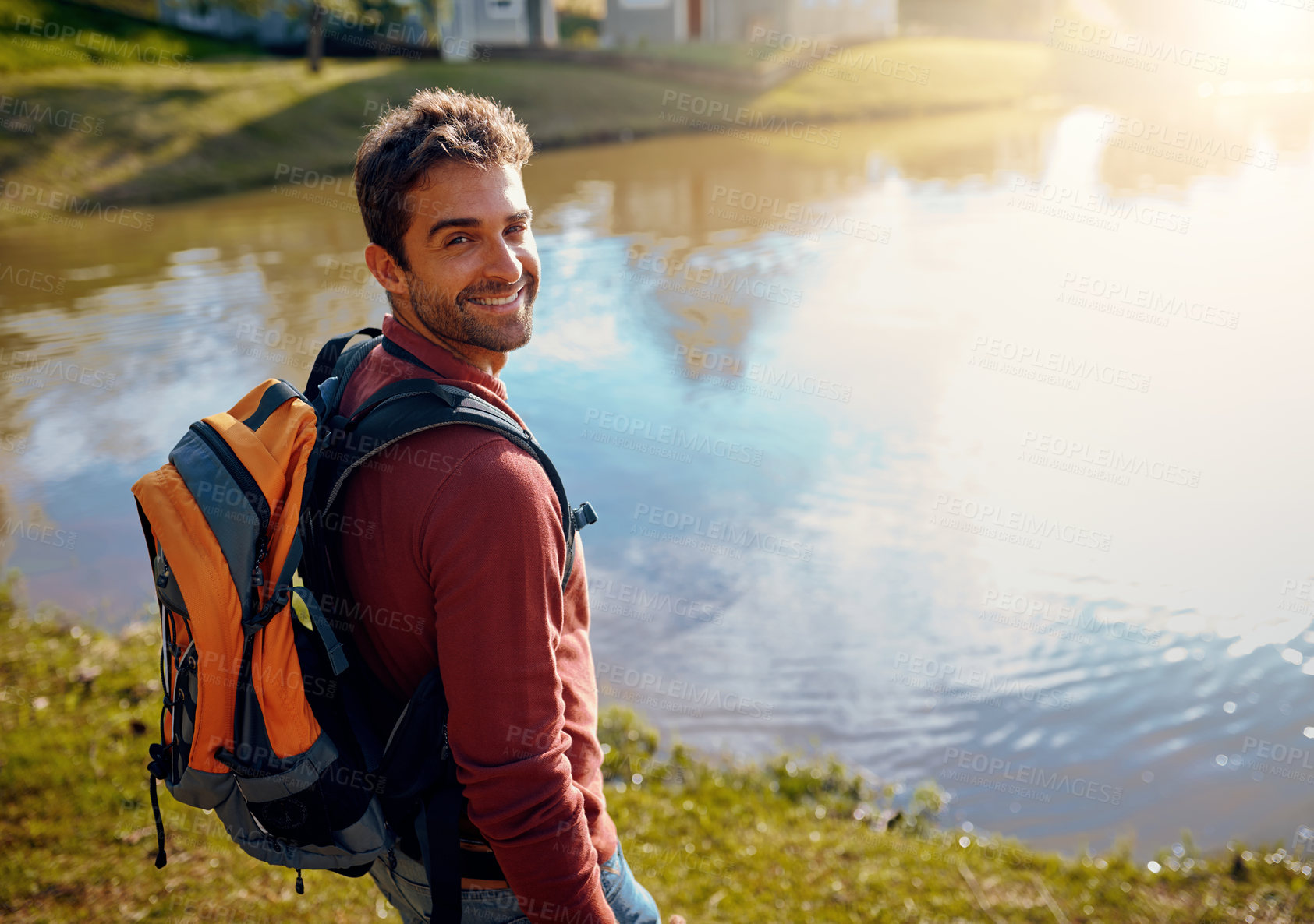Buy stock photo Cropped portrait of a handsome young man spending the day at a lake