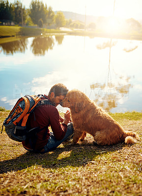 Buy stock photo Full length shot of a handsome young man and his dog sitting by a lake in the park