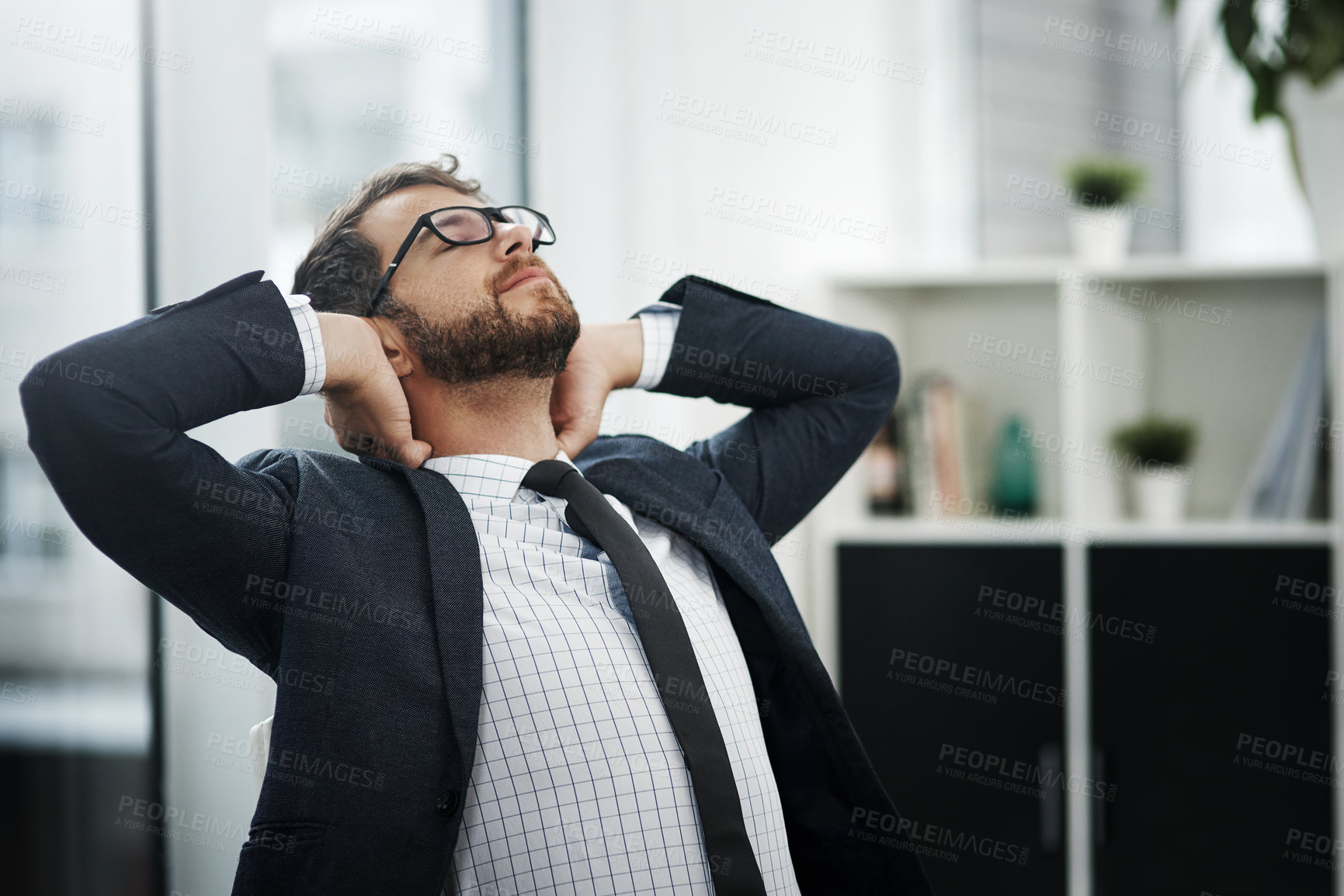 Buy stock photo Shot of a young businessman taking a break in an office