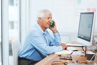 Buy stock photo Cropped shot of a handsome senior businessman making a phonecall while working in his office at home