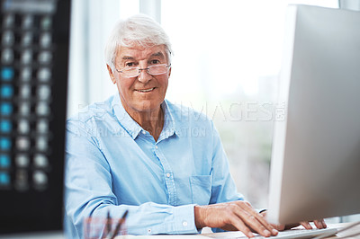 Buy stock photo Cropped portrait of a handsome senior businessman working on his computer at home
