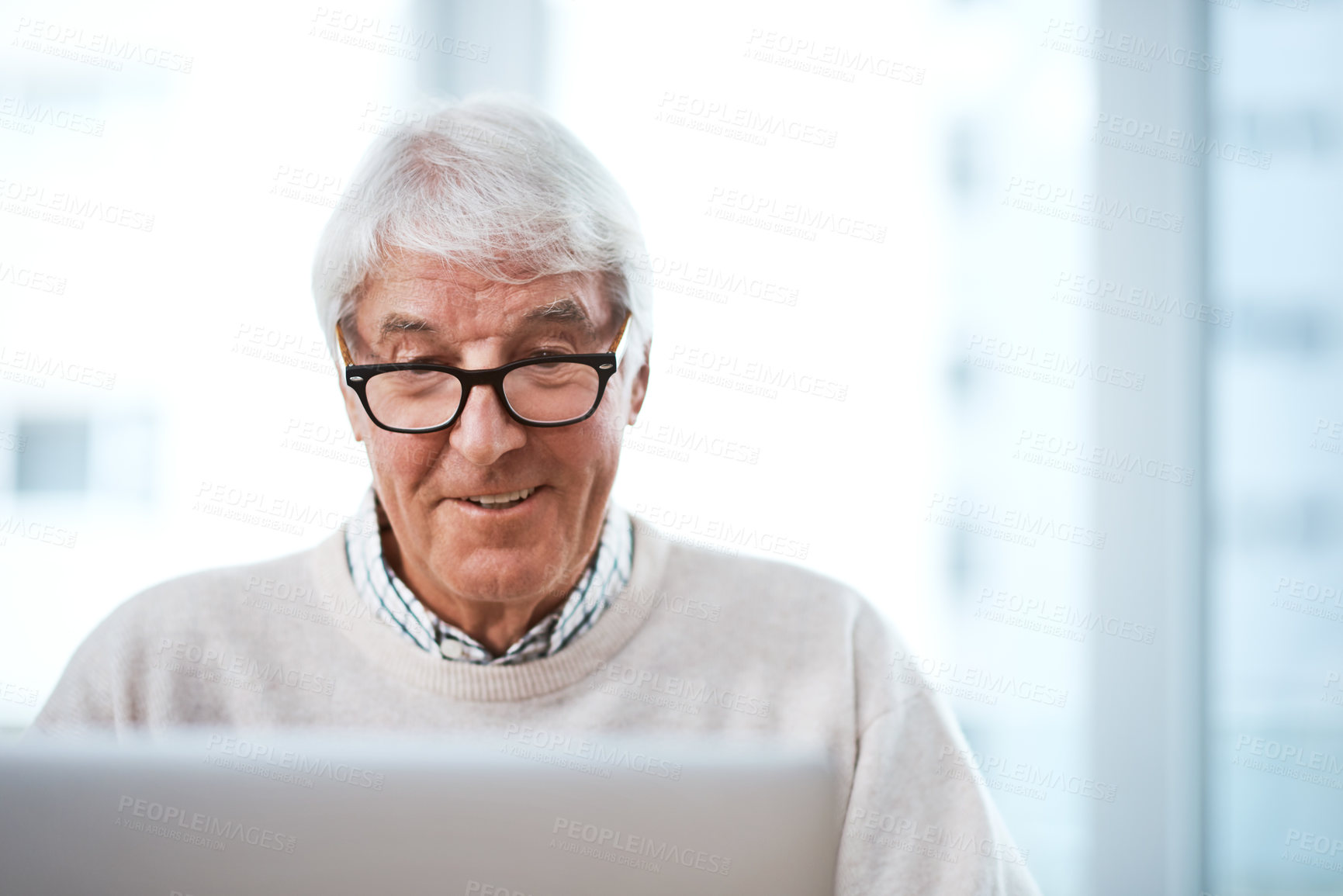 Buy stock photo Cropped shot of a handsome senior businessman working on his laptop at home