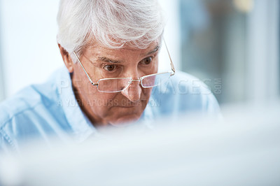 Buy stock photo High angle shot of a handsome senior businessman working on his computer at home