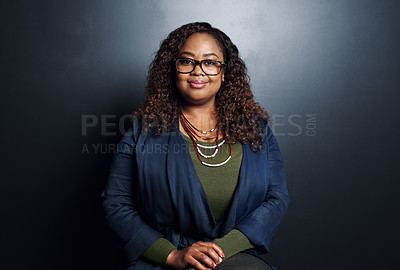 Buy stock photo Cropped portrait of an attractive young businesswoman standing in the studio against a dark background