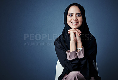 Buy stock photo Cropped portrait of an attractive young businesswoman sitting in the studio against a dark background