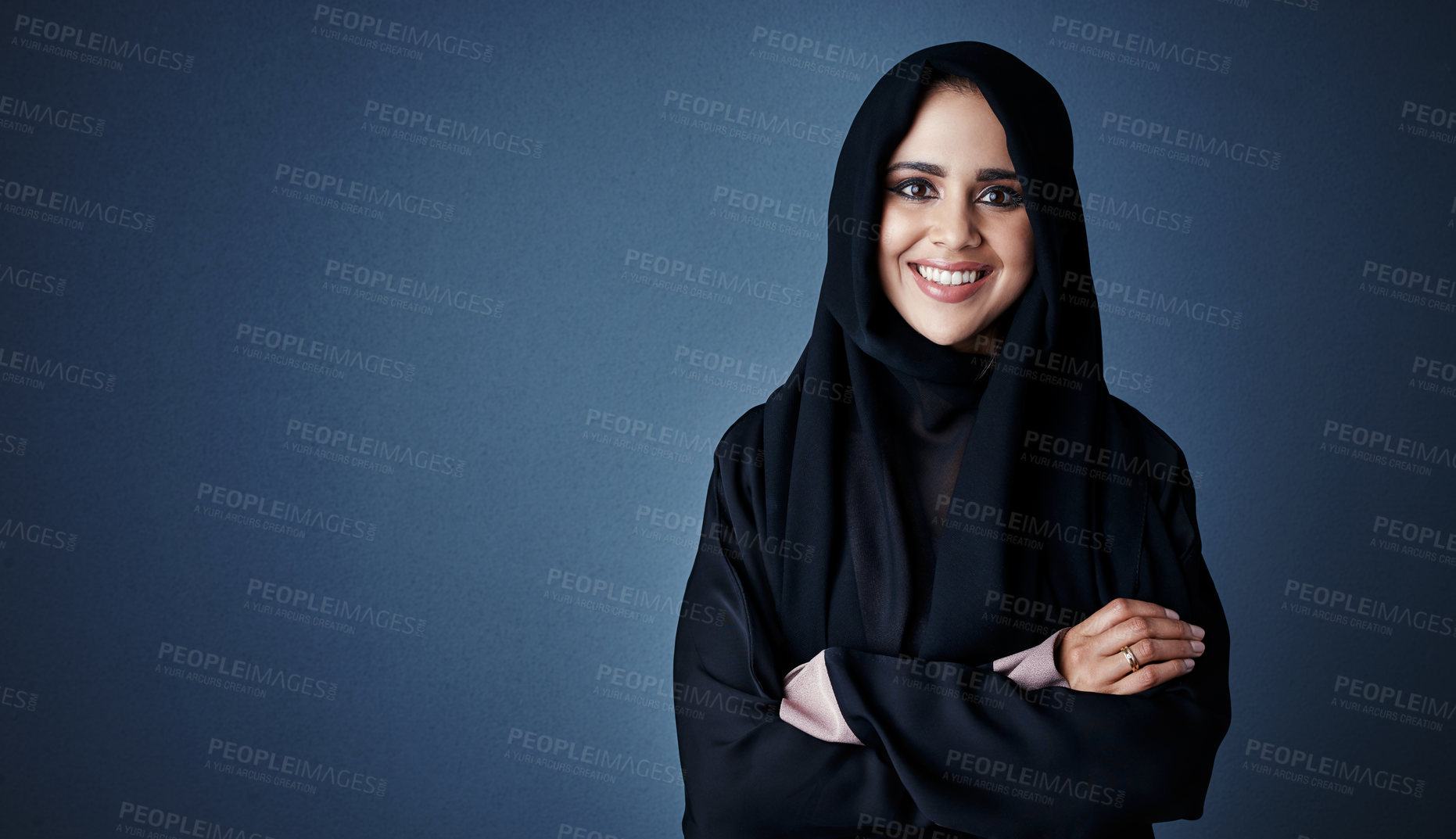 Buy stock photo Cropped portrait of an attractive young businesswoman standing with her arms folded against a dark background