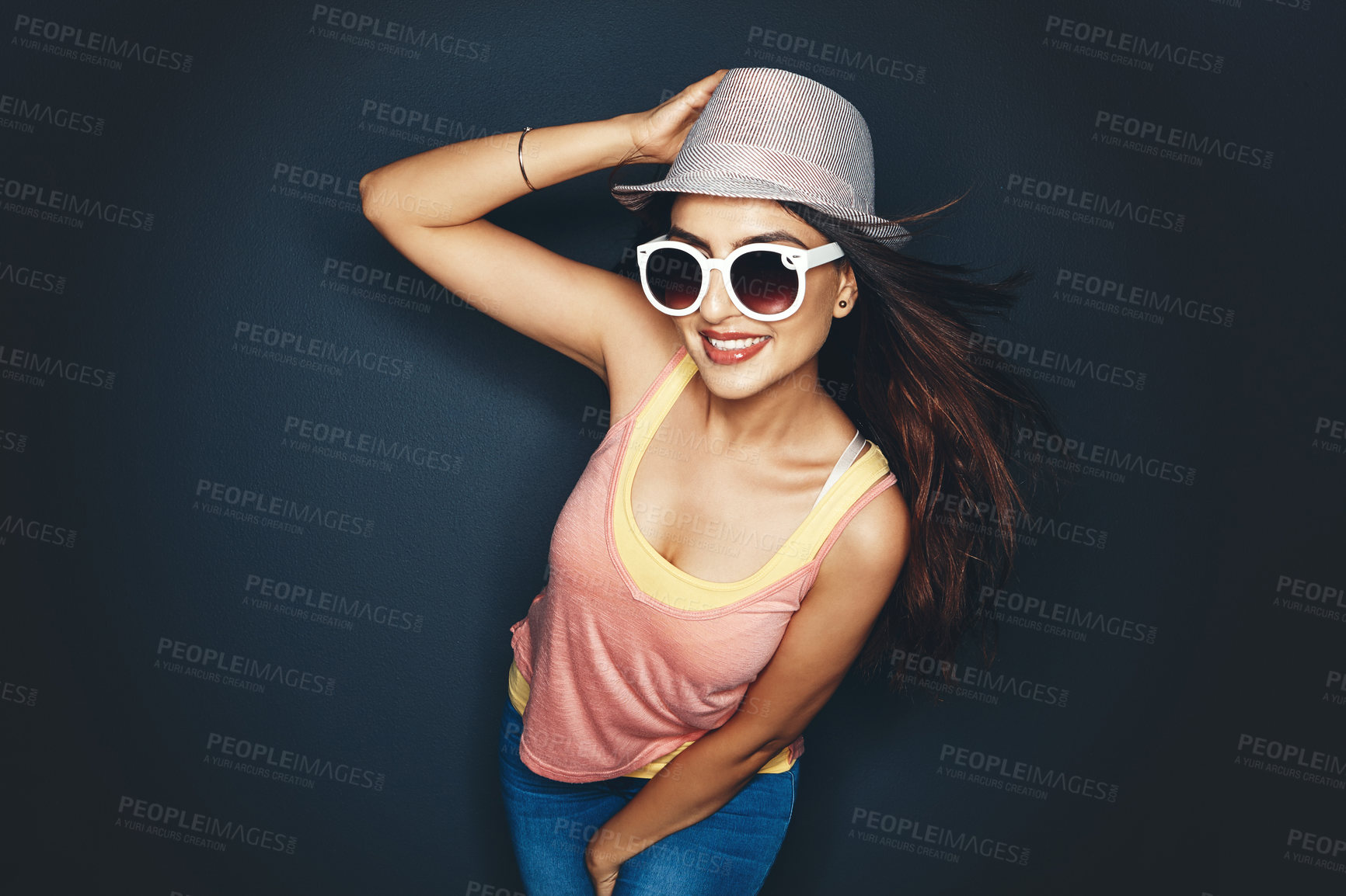 Buy stock photo Studio shot of an attractive and fun loving young woman posing against a dark background