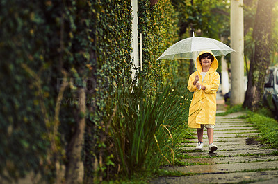 Buy stock photo Shot of an adorable little boy in the rain outside