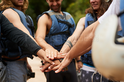 Buy stock photo Cropped shot of a group of young male friends joining hands in unity before going white water rafting