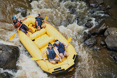 Buy stock photo Shot of a group of young male friends white water rafting