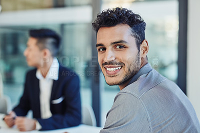 Buy stock photo Portrait of a confident young businessman having a meeting with colleagues in the boardroom of a modern office