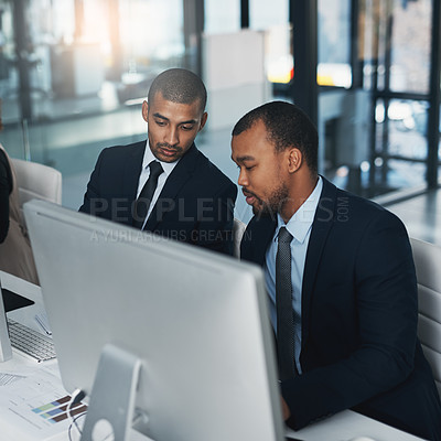 Buy stock photo High angle shot of two corporate businessmen working together on a computer in the office