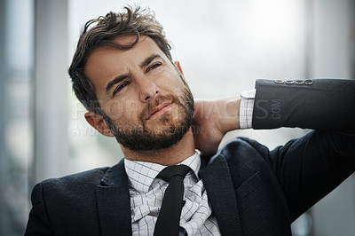 Buy stock photo Shot of a young businessman suffering with neck pain in an office