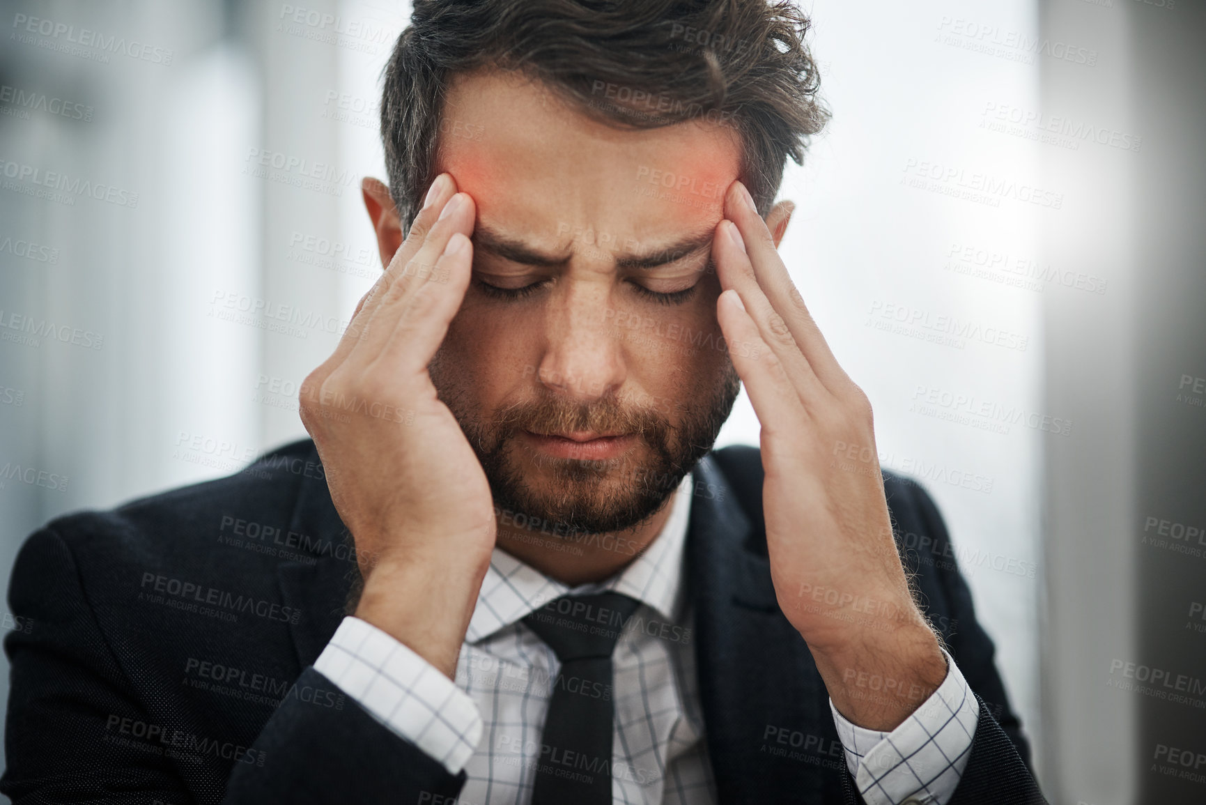 Buy stock photo Shot of a young businessman suffering with a headache in an office