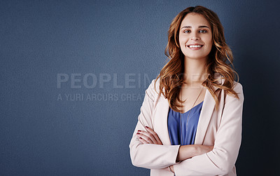 Buy stock photo Studio portrait of an attractive and confident young businesswoman posing against a dark blue background