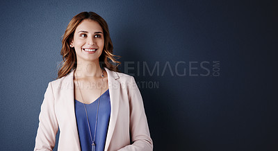 Buy stock photo Studio shot of an attractive young businesswoman looking thoughtful against a dark blue background