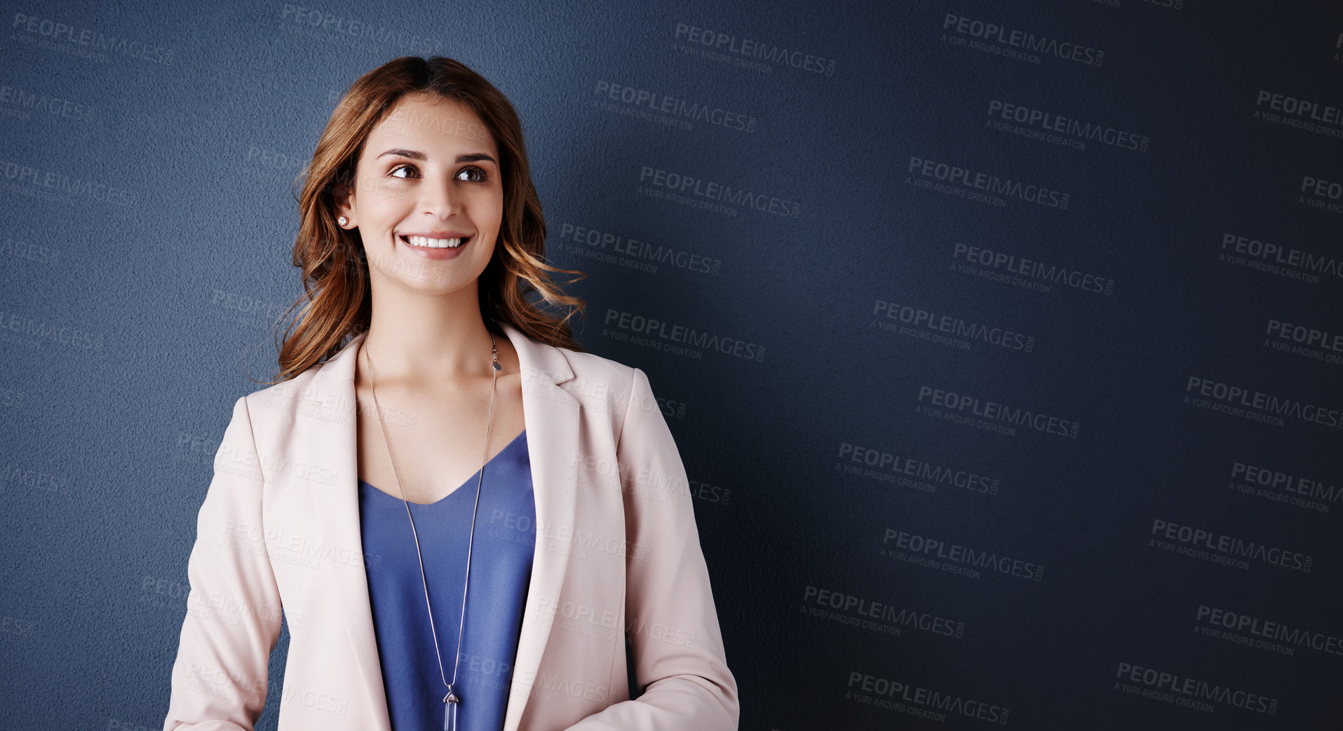 Buy stock photo Studio shot of an attractive young businesswoman looking thoughtful against a dark blue background