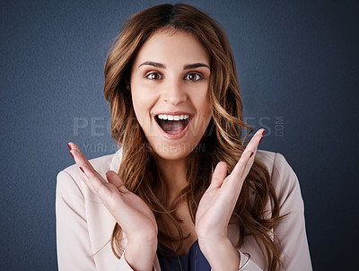 Buy stock photo Studio portrait of an attractive young businesswoman looking surprised against a dark blue background