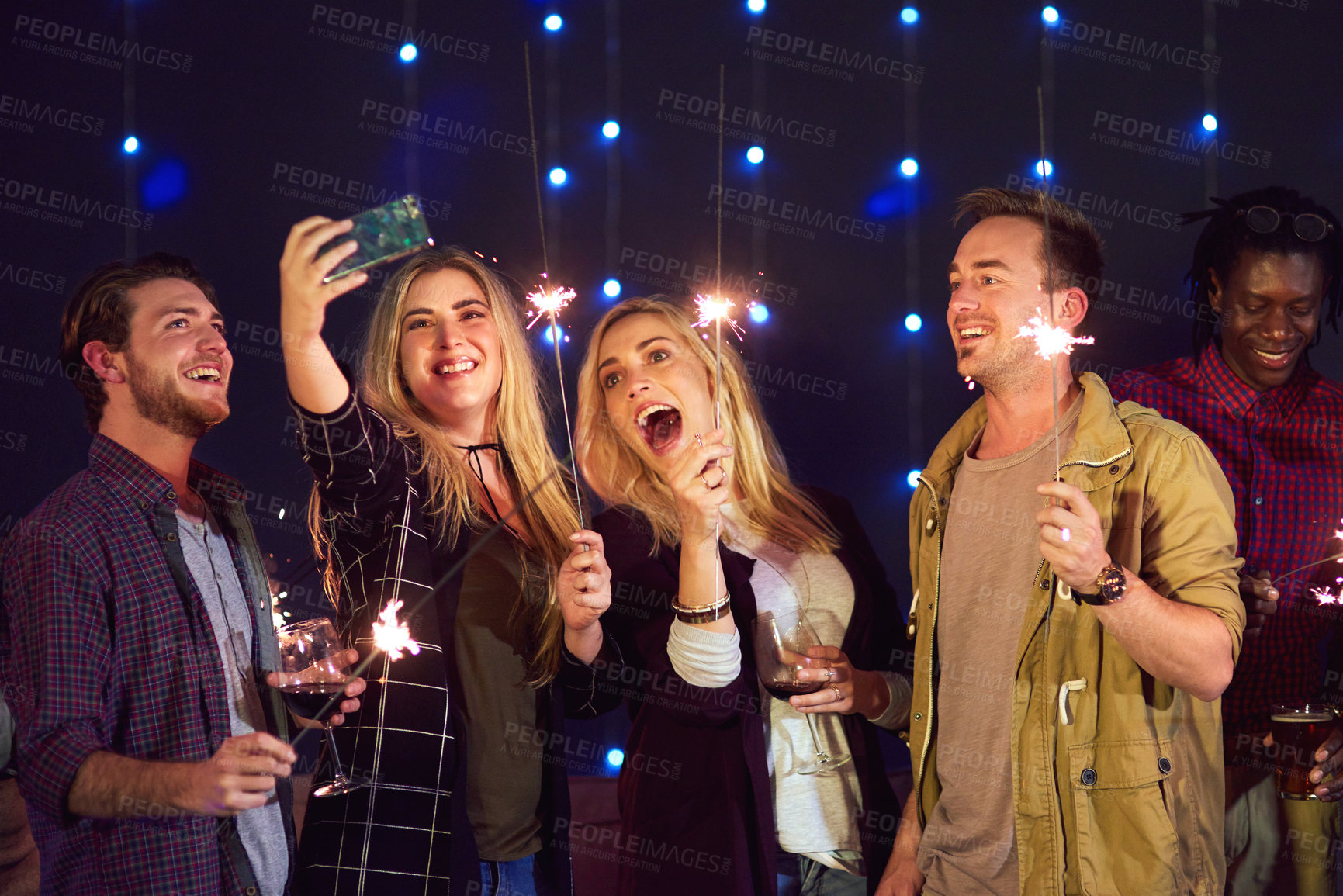 Buy stock photo Cropped shot of a group of friends taking a selfie while having fun at a nightclub