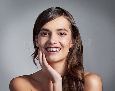Buy stock photo Studio portrait of a beautiful young woman posing against a gray background