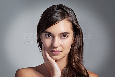Buy stock photo Studio portrait of a beautiful young woman posing against a gray background