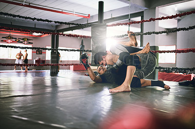 Buy stock photo Shot of two young male boxers facing each other in a training sparing match inside of a boxing ring on the floor at a gym during the day