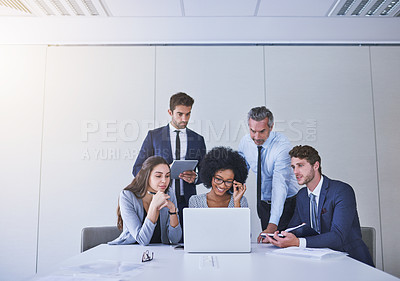 Buy stock photo Shot of a diverse group of businesspeople working together on a laptop in an office