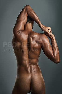 Buy stock photo Rearview studio shot of a muscular young man posing against a grey background