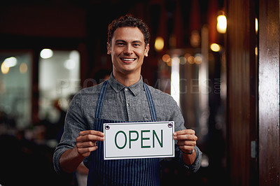Buy stock photo Portrait of a cheerful young business owner holding up a sign saying 