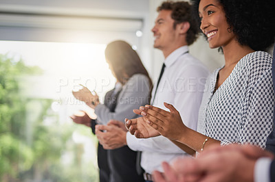 Buy stock photo Shot of a group of young businesspeople standing in a line and applauding in a modern office