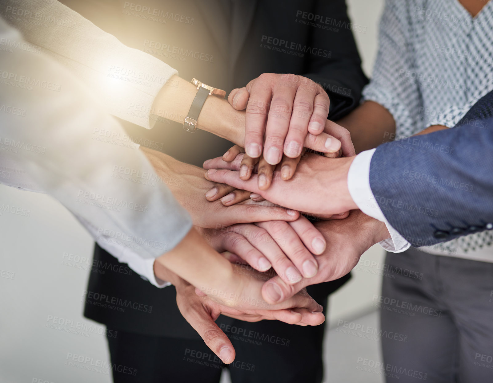 Buy stock photo Cropped shot of a group of colleagues joining hands in solidarity in a modern office