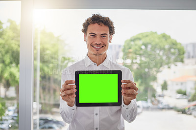 Buy stock photo Portrait of a handsome young businessman holding a digital tablet with a green screen in a modern office
