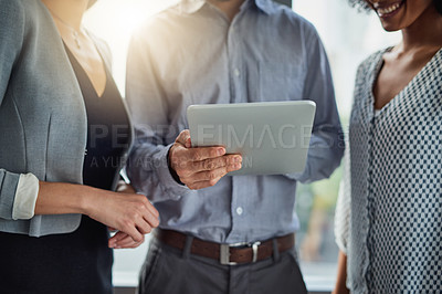Buy stock photo Cropped shot of a group of businesspeople using a digital tablet together in a modern office