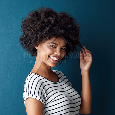 Buy stock photo Woman, portrait and pull curly hair in studio with confidence for growth, results or smile by blue background. African person, girl and model with care, happy or transformation with cosmetic for afro