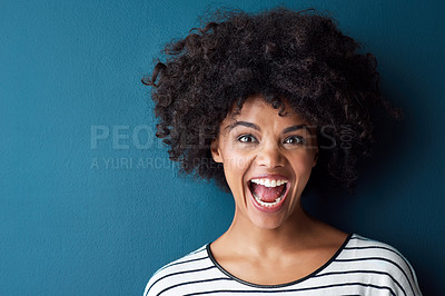 Buy stock photo Studio portrait of an attractive young woman looking surprised against a blue background